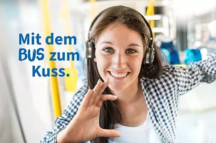 Mädchen mit Kopfhörern im Bus. Sie hält eine imaginäre Karte in der Hand.