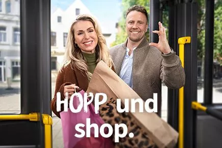 Eine Frau und ein Mann steigen in einen Bus, der Mann zeigt ein imaginäres Ticket. Auf dem Bild steht der Slogan HOPP und shop.