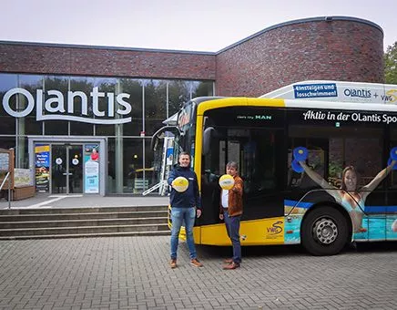 Zwei Männer mit Wasserbällen vor Schwimmbad